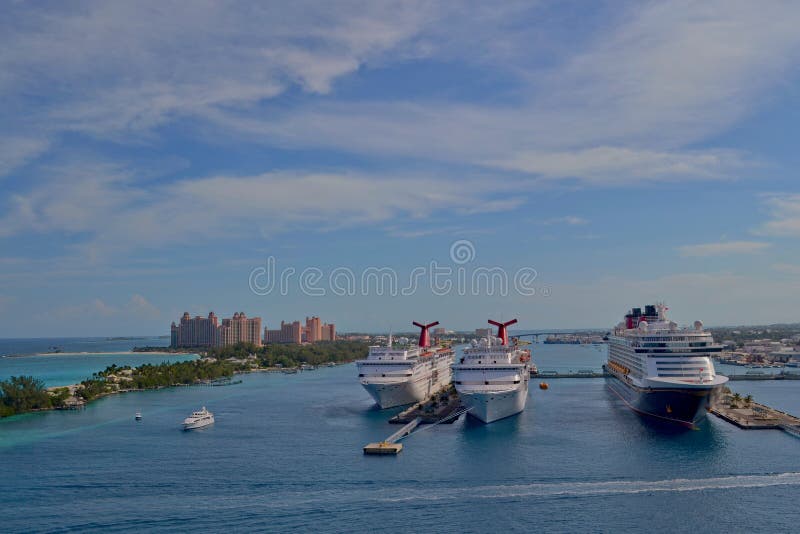 Nassau, Bahamas - 11 de enero de 2015: Vista de barcos de cruceros en el puerto de Nassau y el centro turístico de la Atlántida e imagen de archivo libre de regalías Nassau, Bahamas - 11 de enero de 2015: Vista de barcos de cruceros en el puerto de Nassau y el centro turístico de la Atlántida e imagen de archivo libre de regalías