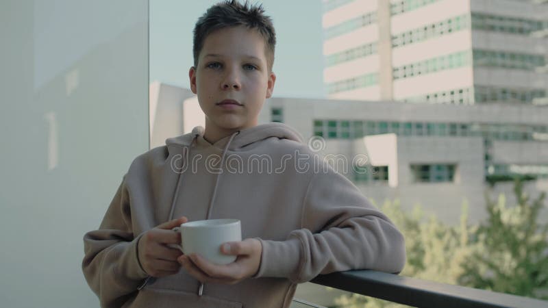 Nastolatek pije kawę stojącą na balkonie zbiory