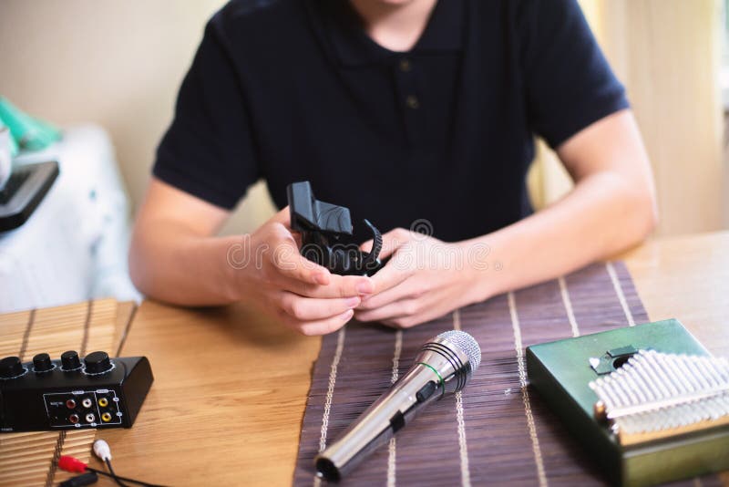 Nastolatek trzyma w rękach stojak mikrofonowy. On montuje ministudio do nagrywania dźwięku obrazy stock
