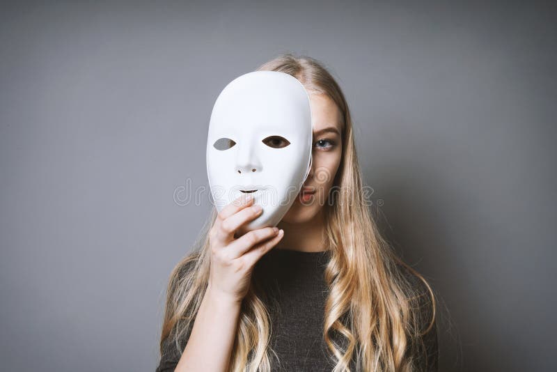 Nastoletnia dziewczyna chuje twarz za maską