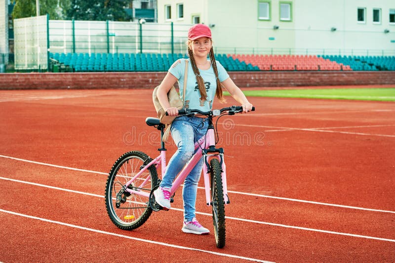 Nastoletnia dziewczyna relaksuje na stadium Dziewczyna sposób życia rowerem obraz stock Nastoletnia dziewczyna relaksuje na stadium Dziewczyna sposób życia rowerem obraz stock