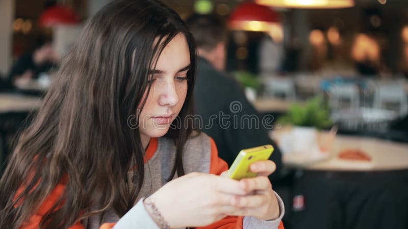 Nastoletnia dziewczyna używa smartphone w kawiarni zbiory wideo