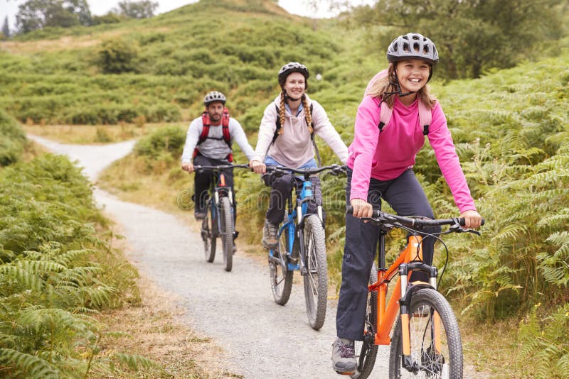 Nastoletniej dziewczyny jeździecki rower górski z ona rodzice podczas rodzinnej campingowej wycieczki, zakończenie w górę