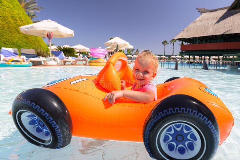 Nataci?n feliz de la ni?a en el coche inflable el vacaciones de verano foto de archivo libre de regalías Nataci?n feliz de la ni?a en el coche inflable el vacaciones de verano foto de archivo libre de regalías