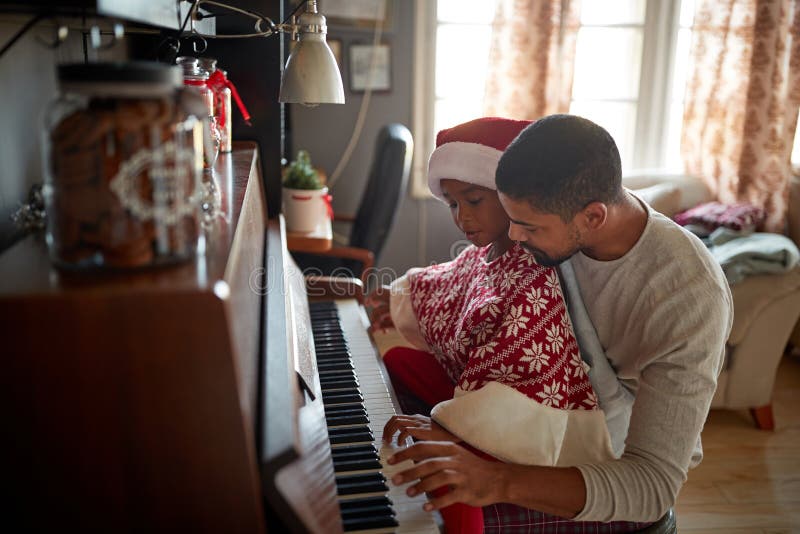 Pai Com a Menina Da Criança Na Música Do Jogo Do Natal No Piano Imagem de  Stock - Imagem de jogar, bonito: 134579623