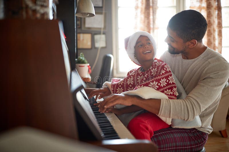 Pai Com a Menina Da Criança Na Música Do Jogo Do Natal No Piano Imagem de  Stock - Imagem de jogar, bonito: 134579623