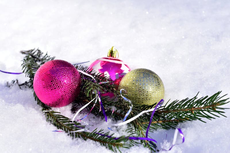 Christmas. Three glass balls and a Christmas tree branch lie in the snow. Decoration for the Christmas tree. Christmas. Three glass balls and a Christmas tree branch lie in the snow. Decoration for the Christmas tree.