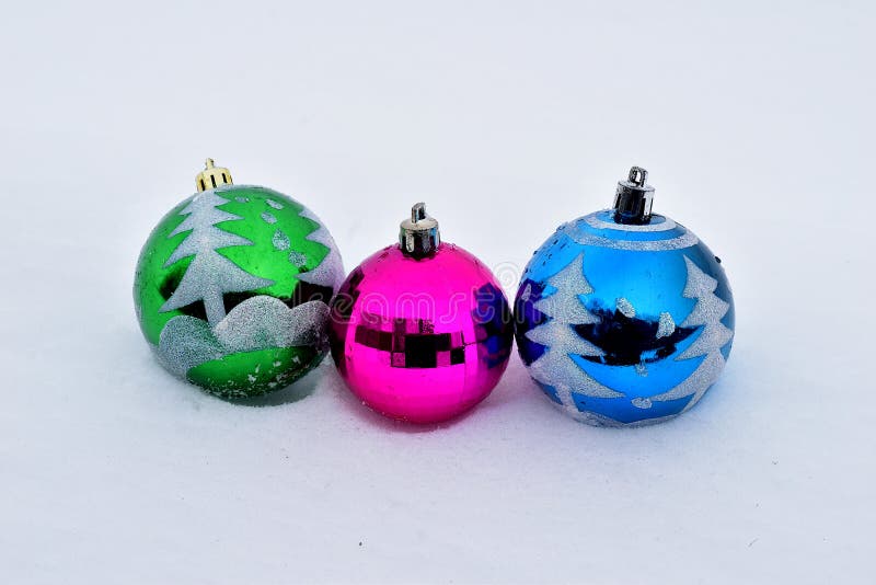 Christmas. Three glass balls lie in the snow. Decoration for the Christmas tree. Christmas. Three glass balls lie in the snow. Decoration for the Christmas tree.