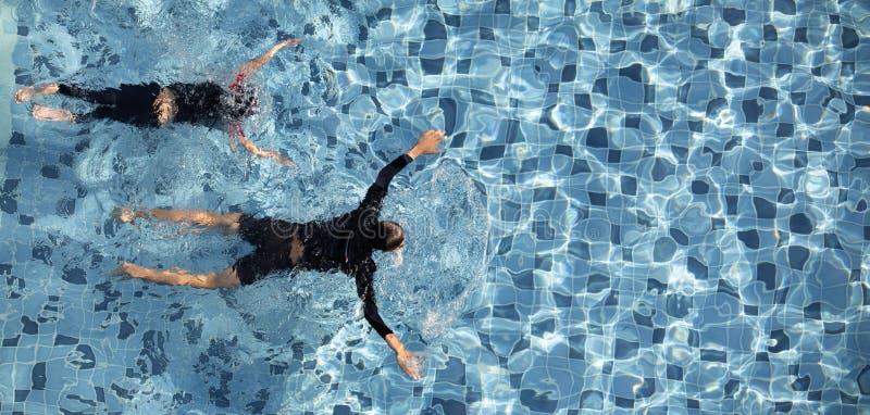 Natation de deux garçons dans la piscine ensemble photographie stock libre de droits Natation de deux garçons dans la piscine ensemble photographie stock libre de droits