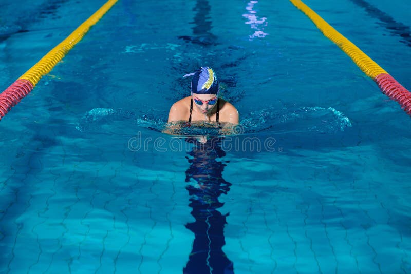 Natation de femme avec le chapeau de natation dans la piscine image libre de droits Natation de femme avec le chapeau de natation dans la piscine image libre de droits