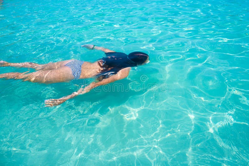 Bikini girl swimming in clear Ibiza beach tropical turquoise Mediterranean. Bikini girl swimming in clear Ibiza beach tropical turquoise Mediterranean