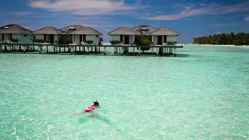 Natação da mulher nova em uma lagoa coral