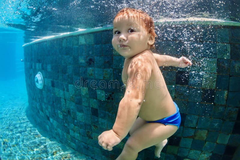 Natação e mergulho pequenos do bebê na associação com divertimento fotografia de stock Natação e mergulho pequenos do bebê na associação com divertimento fotografia de stock