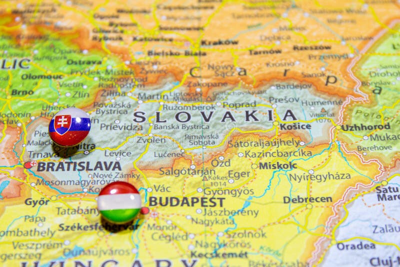 Státní vlajka Slovenska připnutá na mapě politické Evropy. Makro Zblízka obrázek na barevném a rozmazaném atlasu světa