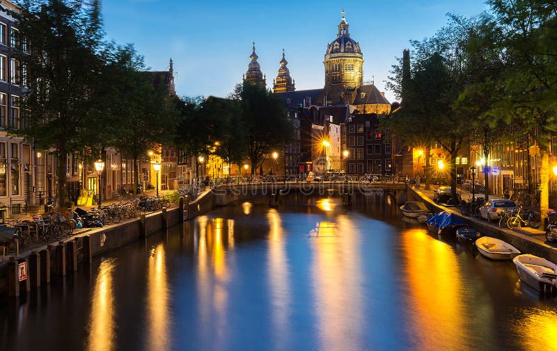 Nattbordellkvarter De Wallen, kanal, basilika av St Nicholas och bro, Amsterdam, Holland exponering long arkivfoto Nattbordellkvarter De Wallen, kanal, basilika av St Nicholas och bro, Amsterdam, Holland exponering long arkivfoto