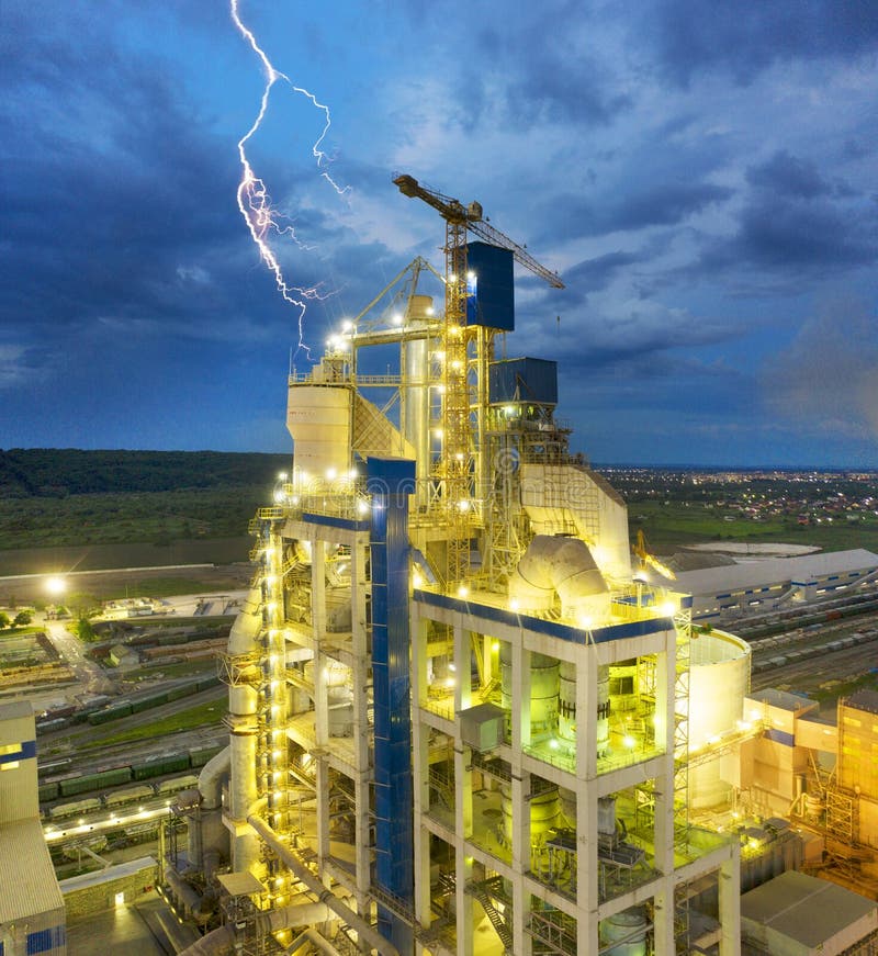 Large plant, aerial photo drone. Large metal structures, pipes, a railway line with hundreds of wagons, bright lighting, energy and power metallurgy. Bright lightning near the tower. Large plant, aerial photo drone. Large metal structures, pipes, a railway line with hundreds of wagons, bright lighting, energy and power metallurgy. Bright lightning near the tower