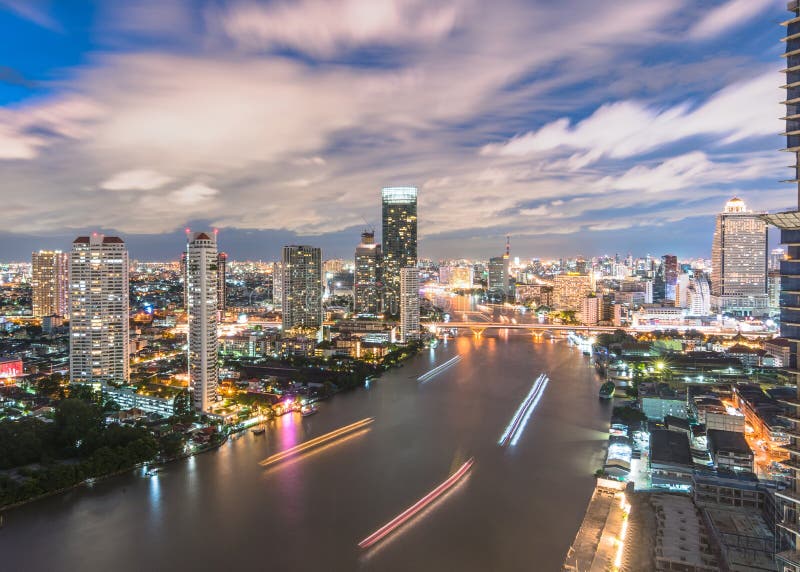 Nattflyg från tak över bangkoks chao phraya flod cbd och hotellaffärsdistrikt efter solnedgång royaltyfri fotografi