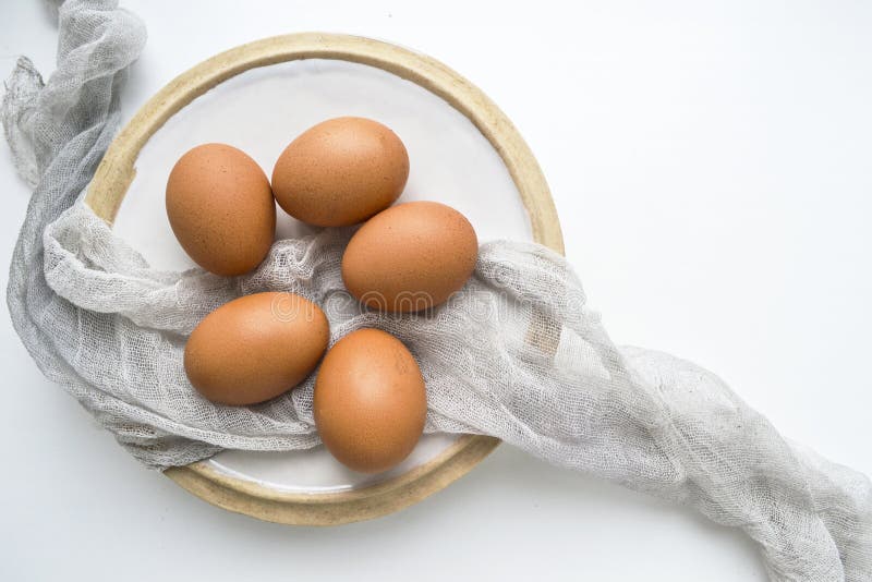 Natura morta con le uova crude fresche sul piatto su fondo bianco Copi lo spazio fotografia stock libera da diritti Natura morta con le uova crude fresche sul piatto su fondo bianco Copi lo spazio fotografia stock libera da diritti