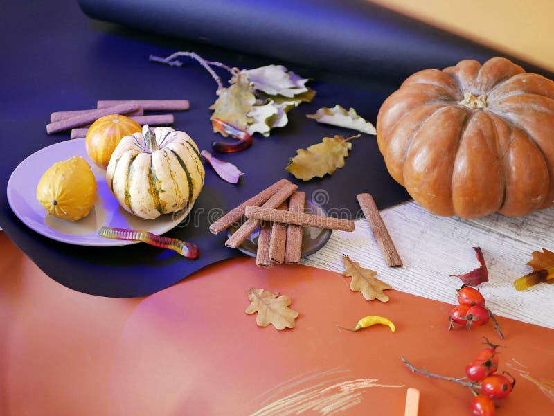 Natura morta decorativa stagionale delle zucche, delle foglie di autunno, biscotti del cioccolato, decorazione di Halloween su un immagini stock libere da diritti Natura morta decorativa stagionale delle zucche, delle foglie di autunno, biscotti del cioccolato, decorazione di Halloween su un immagini stock libere da diritti