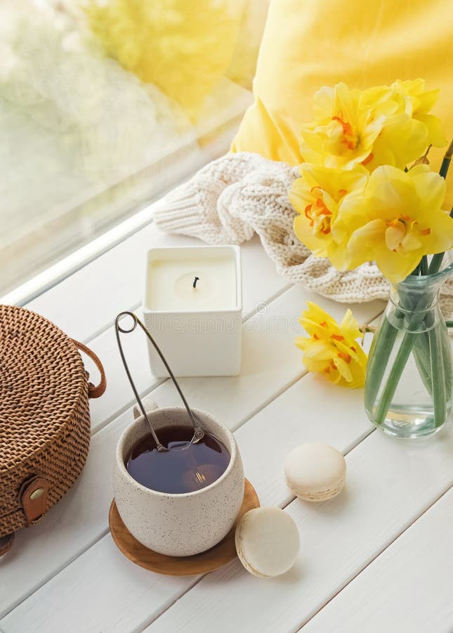 Natura morta della primavera con i fiori gialli, t? e candela, fotografie stock Natura morta della primavera con i fiori gialli, t? e candela, fotografie stock