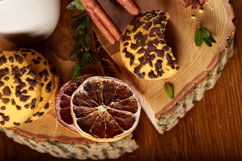 Natura morta di Natale con l'assortimento dei biscotti, della cannella e delle arance secche su un ceppo, primo piano, fuoco sele fotografia stock Natura morta di Natale con l'assortimento dei biscotti, della cannella e delle arance secche su un ceppo, primo piano, fuoco sele fotografia stock