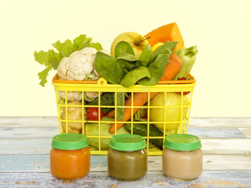 Natural baby food concept: jars with vegetable puree and basket with vegetables on the light wooden background royalty free stock image Natural baby food concept: jars with vegetable puree and basket with vegetables on the light wooden background royalty free stock image