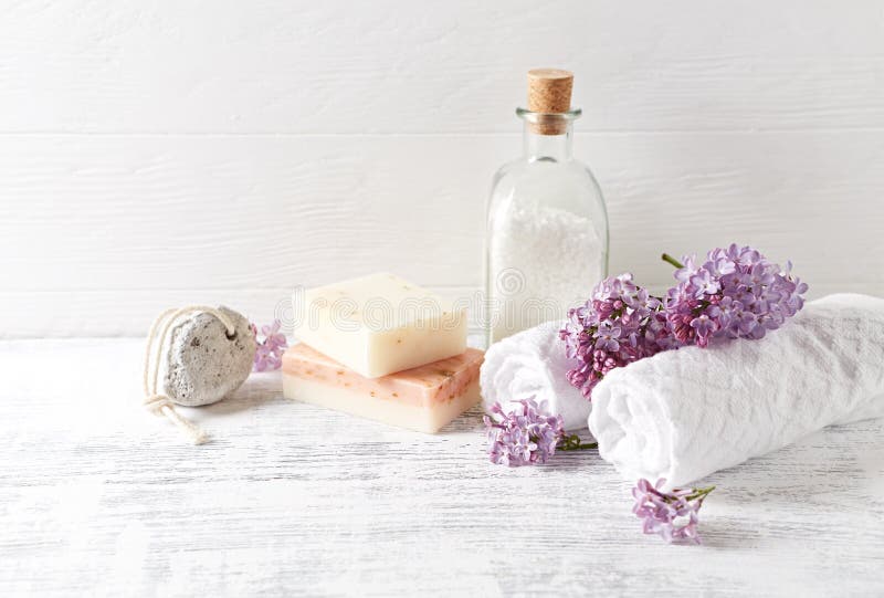 Natural bath salt, soap, cotton towels and lilac flowers symbolic image