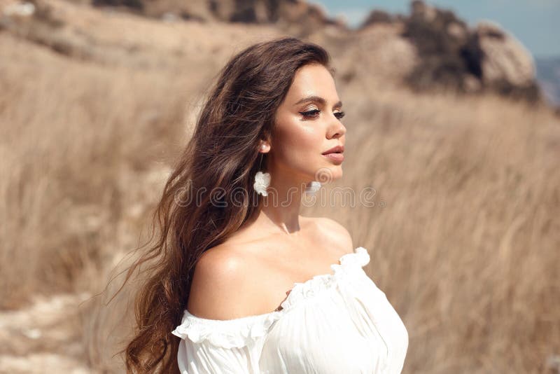 Natural beauty brunette outdoor portrait. Beautiful young bride woman with long wavy hair enjoying in the hay field.  Romantic