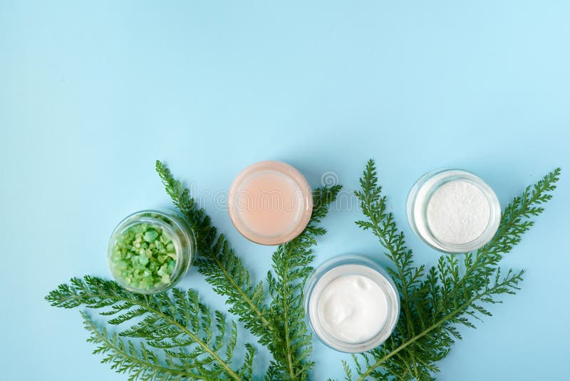Natural beauty product concept for or bathroom. cream, soap,green leaves, sea solt on blue background with copy space. body skin royalty free stock photo Natural beauty product concept for or bathroom. cream, soap,green leaves, sea solt on blue background with copy space. body skin royalty free stock photo