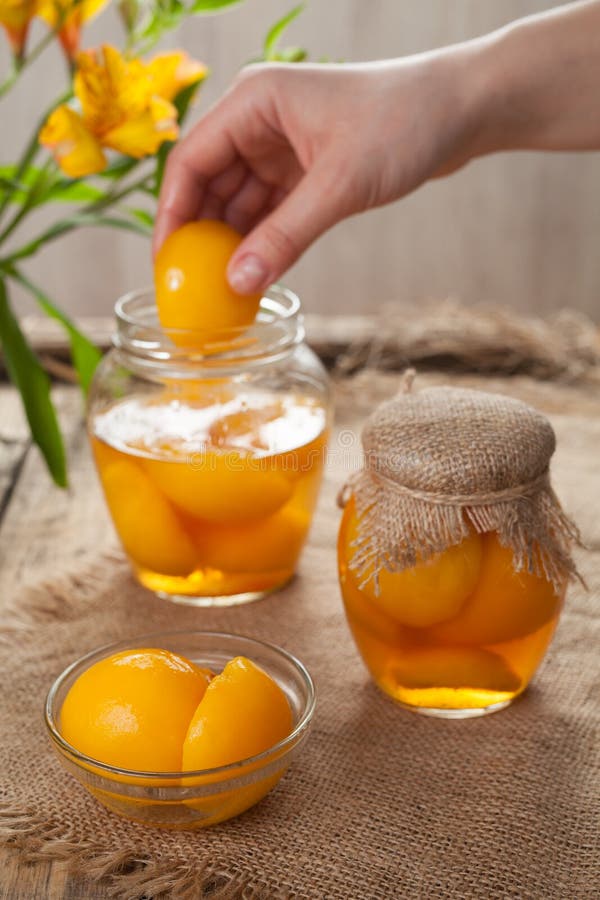 Natural canned peaches in glass jars with compote