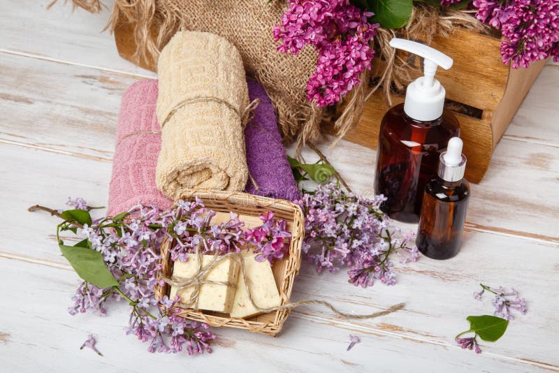 Natural cosmetics with lilac flowers. Serum, soap and cream with towel rolls. stock photos Natural cosmetics with lilac flowers. Serum, soap and cream with towel rolls. stock photos