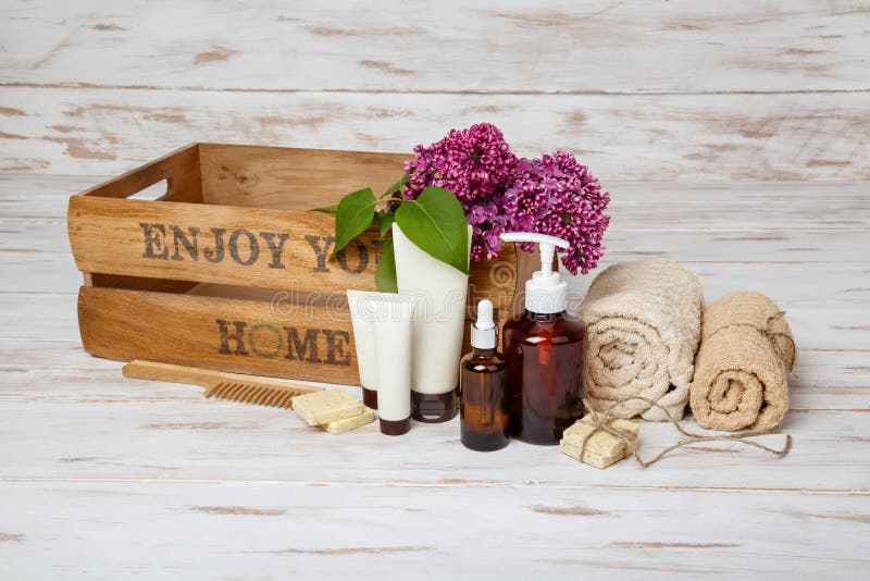 Natural cosmetics with lilac flowers. Serum, soap and cream with towel rolls. stock photography Natural cosmetics with lilac flowers. Serum, soap and cream with towel rolls. stock photography