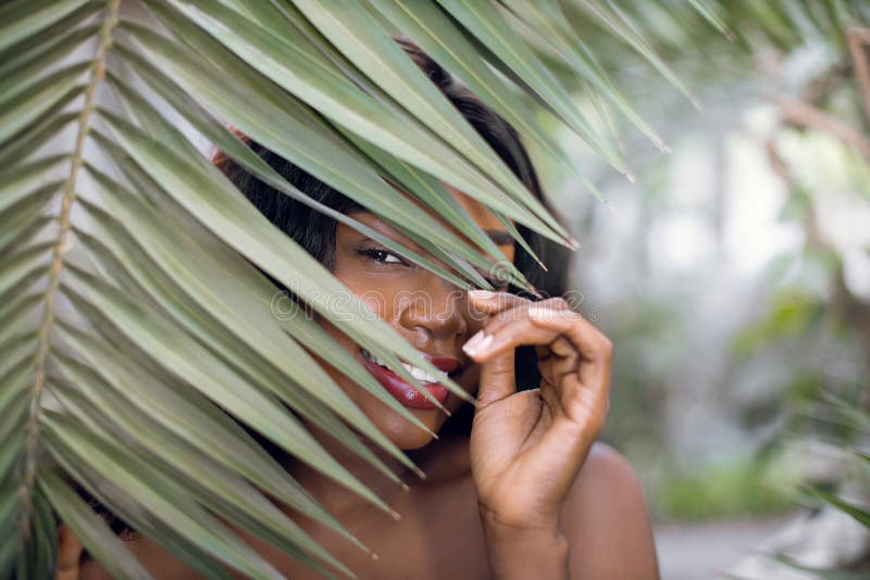 Natural exotic beauty, wellness. Close up portrait of smiling pretty mysterious African woman model, posing to camera