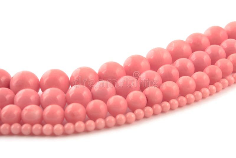 Natural gemstone pink coral beads on a white background.