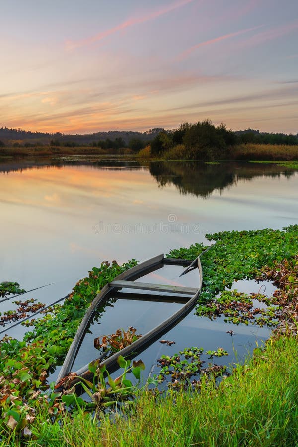 Natural landscape with boats in the water at sunset. Amazing lake with small artisanal fishing boats