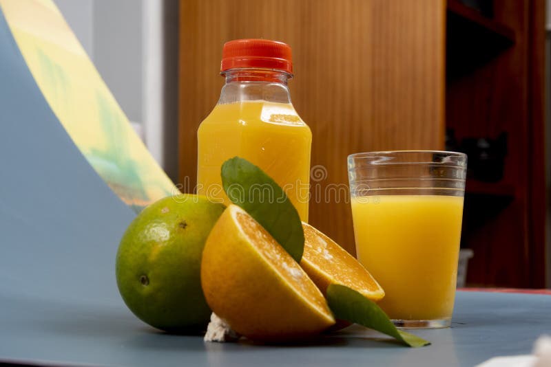 Natural orange juice in the glass with bottle on the side. stock photos