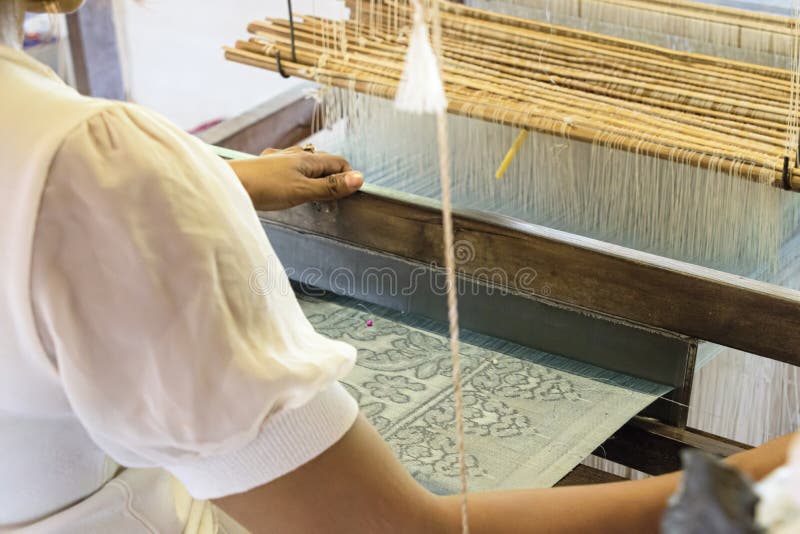 Natural silk farming and handcrafted manufacture of silk artifacts -ladies handweaving ancient patterns in silk on traditional lo