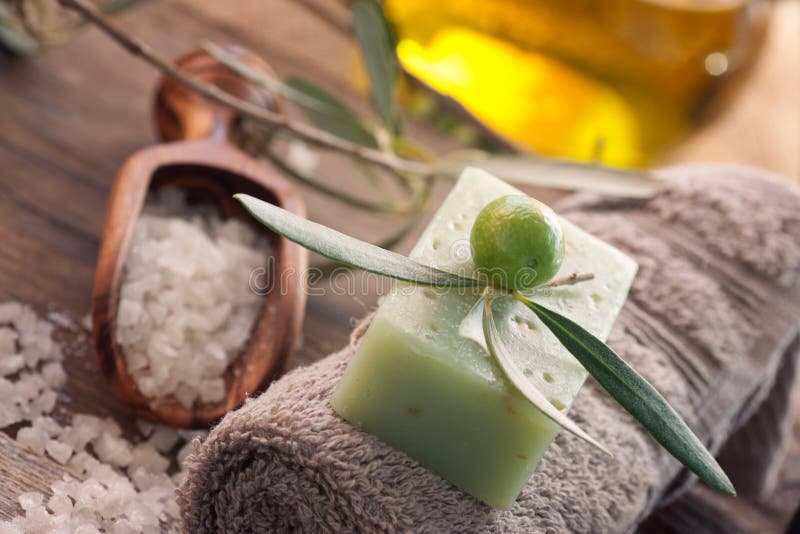 Natural spa setting with olive and olive oil products: bath salt, natural soap and olive oil. Natural spa setting with olive and olive oil products: bath salt, natural soap and olive oil.