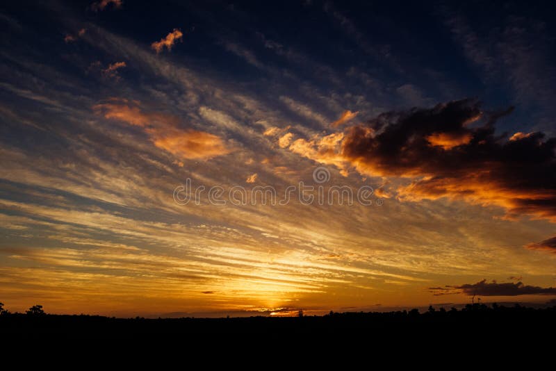 Natural Sunset Sunrise Over Field Or Meadow. Bright Dramatic Sky And Dark Ground. Countryside Landscape Under Scenic Colorful Sky stock images Natural Sunset Sunrise Over Field Or Meadow. Bright Dramatic Sky And Dark Ground. Countryside Landscape Under Scenic Colorful Sky stock images