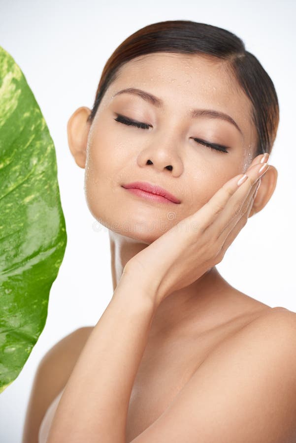Naturalne piękno. Młoda kobieta używa naturalnych skincare produkty dla ona twarz