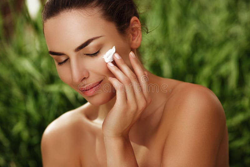Naturalny pokojowy portret piękna dziewczyna z czystą skórą robi skincare z creme outdoors zdjęcia royalty free Naturalny pokojowy portret piękna dziewczyna z czystą skórą robi skincare z creme outdoors zdjęcia royalty free