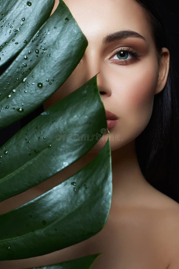 Nature Beauty. beautiful girl with palm leaf. Beautiful young woman