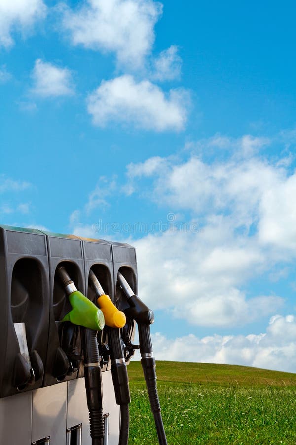 Three gas pump nozzles over a nature background. Three gas pump nozzles over a nature background