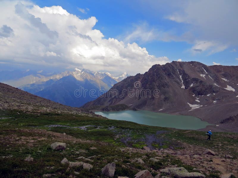 Nature image with Caucasus mountains, lake and clouds