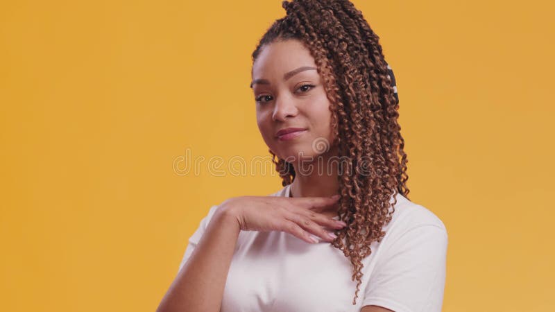 Naturlig. studio portrait av söt afrikansk amerikan-dam som pockar på kamerans orange bakgrund