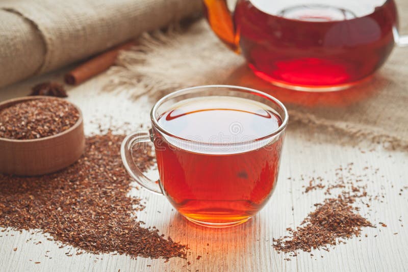 Natural organic tasty traditional african tea rooibos with antioxidants served in glass cup with spices on vintage wooden table in rustic style with vintage. Natural organic tasty traditional african tea rooibos with antioxidants served in glass cup with spices on vintage wooden table in rustic style with vintage