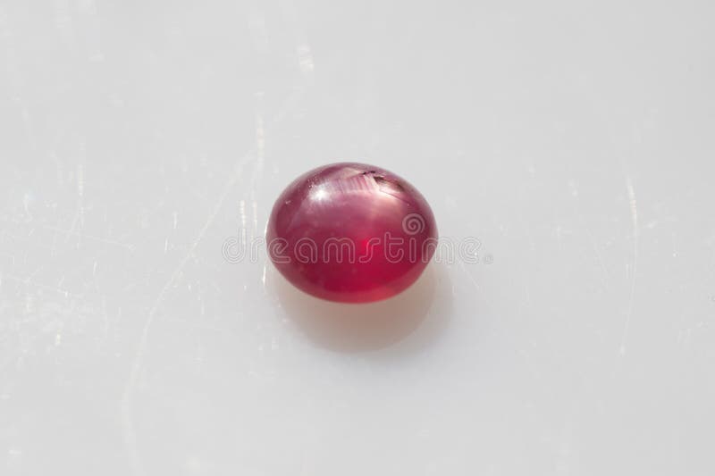 Naturligt 6 Star Red Ruby Gemstone Polshed Cabochon på Glossy White Surface arkivfoto