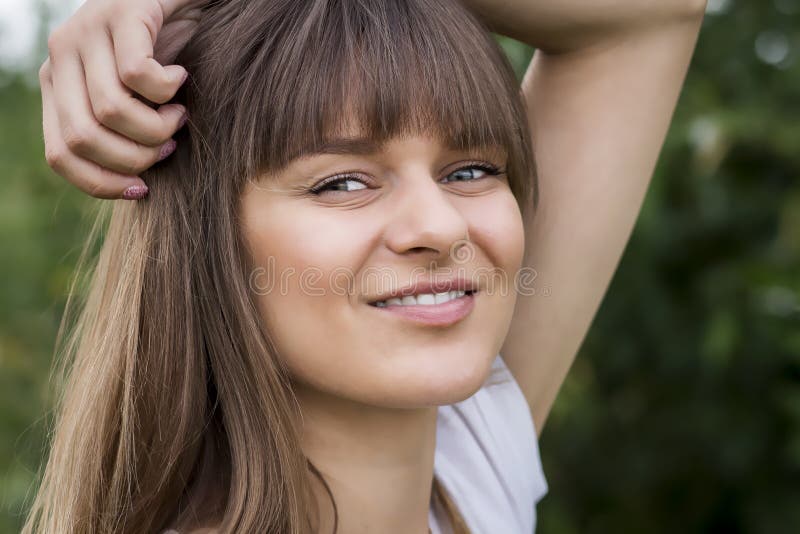 Natuurlijk portret van leuk mooi meisje die haar haar in handen houden en in de zomerpark glimlachen Vrij Kaukasische vrouw in go royalty-vrije stock foto Natuurlijk portret van leuk mooi meisje die haar haar in handen houden en in de zomerpark glimlachen Vrij Kaukasische vrouw in go royalty-vrije stock foto