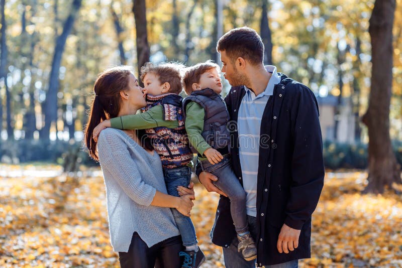 Natuurlijke beelden van een gelukkige familie van vier die pret outsiade op een zonnige de herfstdag hebben Samenhorigheid en gel stock afbeelding Natuurlijke beelden van een gelukkige familie van vier die pret outsiade op een zonnige de herfstdag hebben Samenhorigheid en gel stock afbeelding