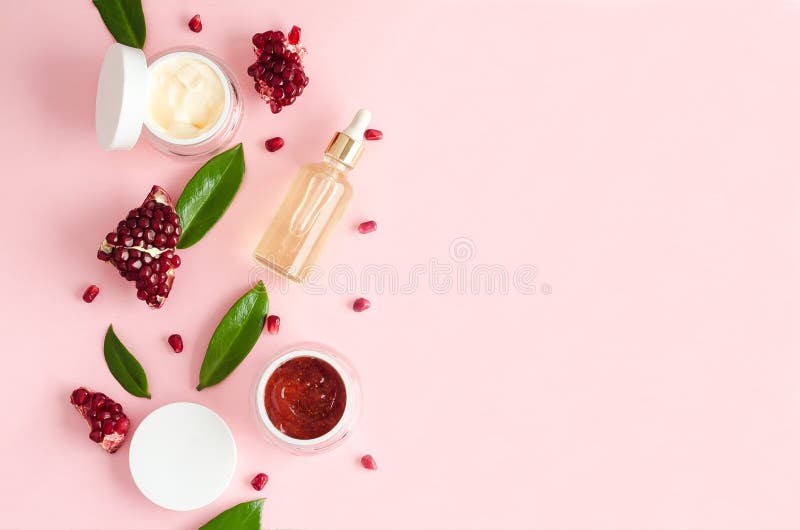 Natuurlijke organische cosmetische producten met aha-vruchtensoorten extract granaatolie op roze achtergrond.